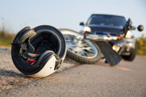 A helmet on the ground in front of a crashed motorcycle. How much can I get from a motorcycle injury lawsuit in Washington?