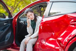 woman in a damaged car after a hit and run. What to do if you’re in a hit and run accident in Everett.